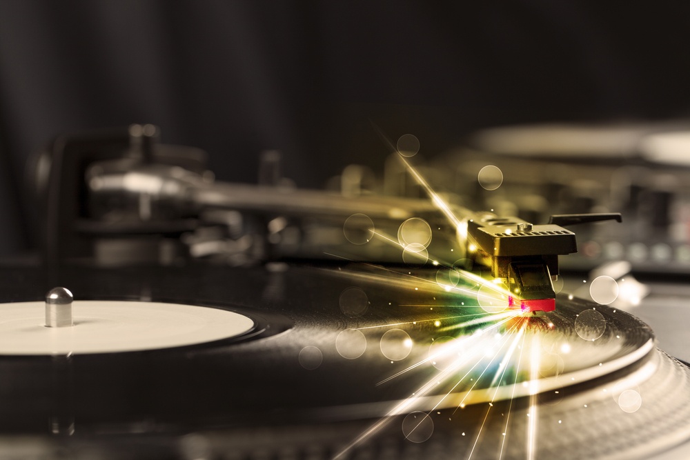 Music player playing vinyl with glow lines comming from the needle concept on background.jpeg
